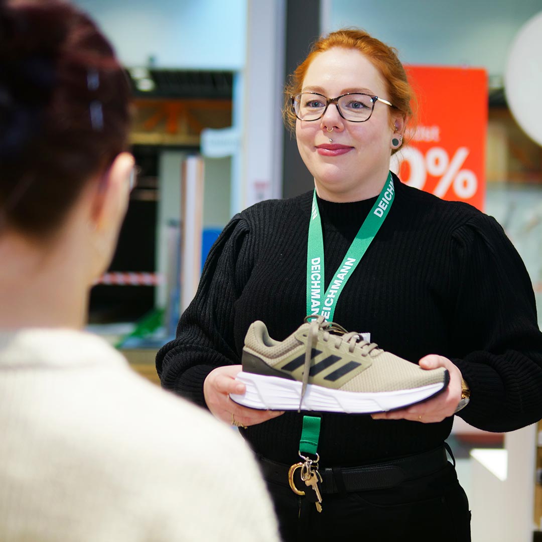 Medarbejder fremviser et par flotte sko i Glostrup Shoppingcenter