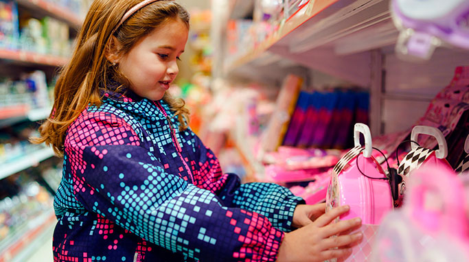 Pige kigger længselsfuldt på ting i butik